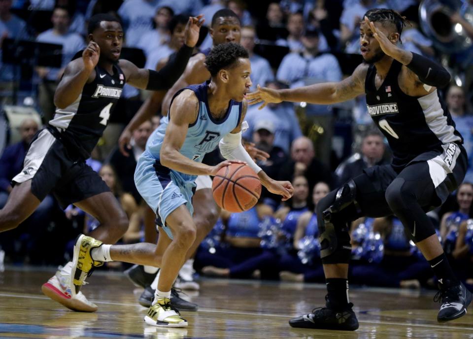 URI’s Fatts Russell is defended by PC’s Nate Watson during their annual rivalry game on Dec. 6, 2019. The teams have not played each other since then. Last year's game was canceled because of COVID-19 concerns.