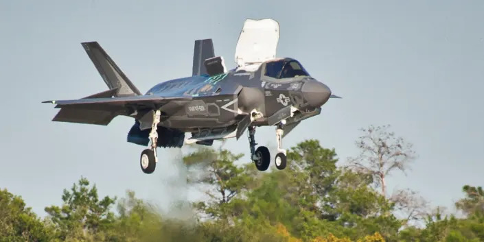 A Marine F-35B joint strike fighter hovers over the runway as it descends toward the ground during the first short take-off and vertical landing mission at Eglin Air Force Base, Fla., Oct. 25, 2013.