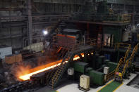 In this July 24, 2019, photo, red-hot steel rolls along a conveyor inside a mill of Ansteel's Bayuquan Production Base in Yingkou in northeastern China's Liaoning Province. Authorities in China's rust-belt region are looking for support for its revival from Beijing's multibillion-dollar initiative to build ports, railways and other projects abroad. (AP Photo/Olivia Zhang)