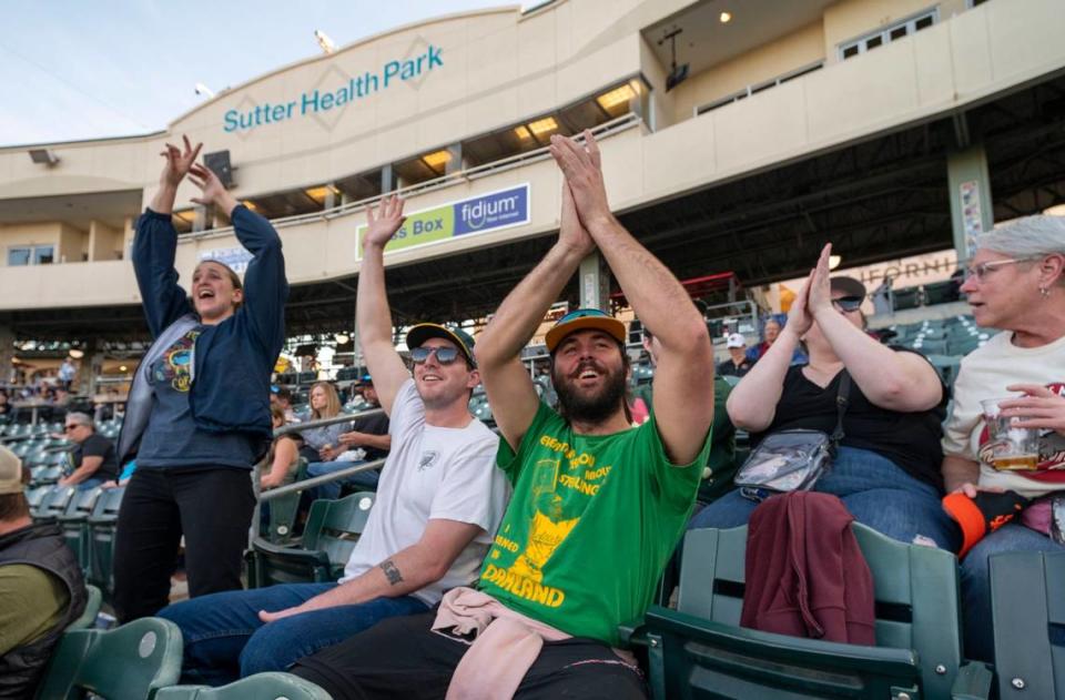 Oakland A’s fans Michaela, left, and Robert Clemons, center, of West Sacramento and Riley Moore, right, from the Bay Area watch the Sacramento River Cats play the El Paso Chihuahuas on Tuesday at Sutter Health Park.