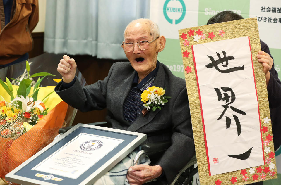 In this handout picture taken and released by Guineess World Records LTD. via Jiji Press on February 12, 2020 Japanese Chitetsu Watanabe, aged 112, poses next to the calligraphy reading in Japanese 'World Number One' after he was awarded as the world's oldest living male in Joetsu, Niigata prefecture. - A 112-year-old Japanese man who believes smiling is the key to longevity has been recognised as the world's oldest male, Guinness World Records said on February 12, 2020. (Photo by STR / 2019 Guinness World Records Ltd via Jiji Press / AFP) / Japan OUT / RESTRICTED TO EDITORIAL USE - MANDATORY CREDIT "AFP PHOTO /  2019 GUINNESS WORLD RECORDS LTD. / JIJI PRESS" - NO MARKETING - NO ADVERTISING CAMPAIGNS - DISTRIBUTED AS A SERVICE TO CLIENTS (Photo by STR/2019 Guinness World Records Ltd /AFP via Getty Images)