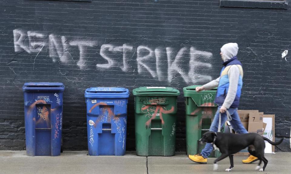 A pedestrian walks past graffiti that reads ‘rent strike’ in Seattle, Washington, on 1 April.