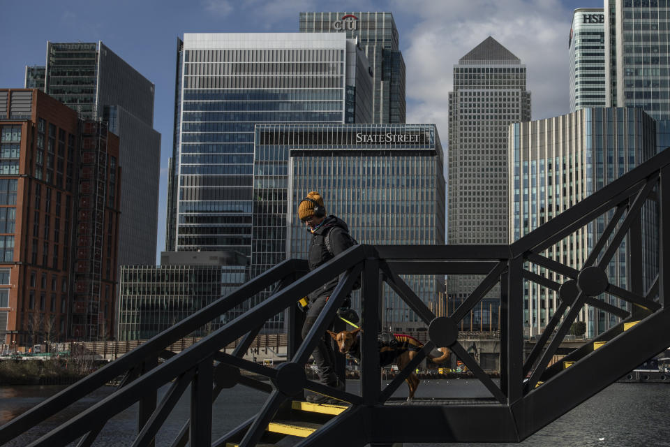 A woman walk her dog over a bridge near the Canary Wharf business district. Photo: Dan Kitwood/Getty Images