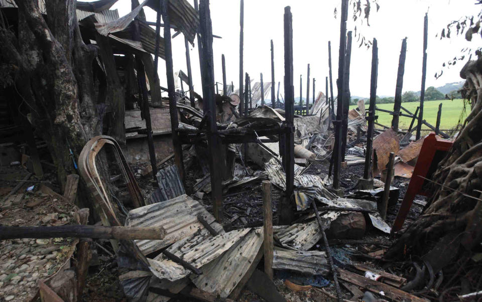 Totally blackened pillars stand among debris of a burnt building Wednesday, Oct. 2, 2013, in Thandwe, Rakhine State, western Myanmar. Terrified Muslim families hid in forests in western Myanmar on Wednesday, one day after rampaging Buddhist mobs killed a 94-year-old woman and burned dozens of homes despite the first trip to the volatile region by President Thein Sein since unrest erupted last year. The violence near Thandwe, a coastal town the president was due to visit later Wednesday on the second day of his tour of Rakhine state, raised new questions about government's failure to curb anti-Muslim attacks and or protect the embattled minority. (AP Photo/Khin Maung Win)