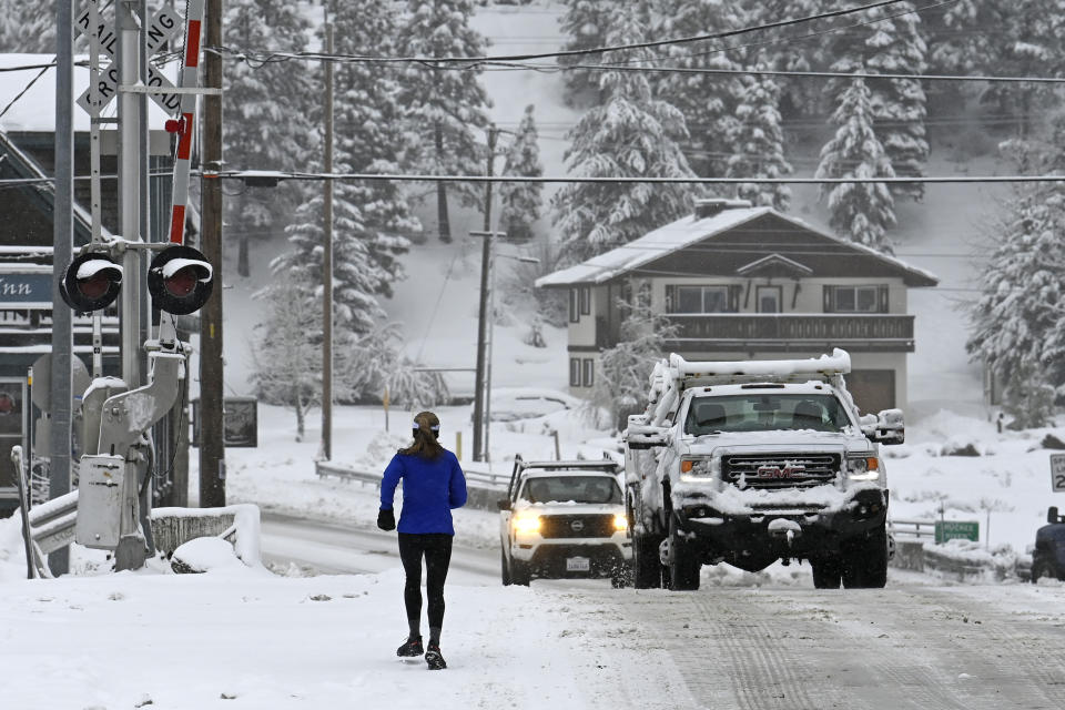 local runner Jenelle Potvin goes on her daily jog along Bridge Street on Friday, March 1, 2024, in Truckee, Calif. The most powerful Pacific storm of the season is forecast to bring up to 10 feet of snow into the Sierra Nevada by the weekend (AP Photo/Andy Barron)