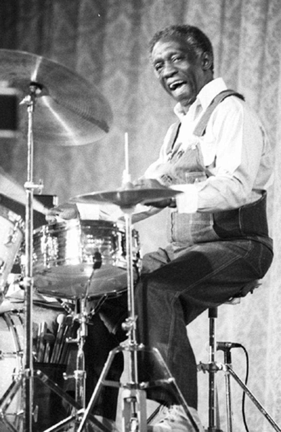 <p>The maestro jazz drummer Art Blakey was known for his aggressive swing style. His hands could move at the speed of light, and he was among one of the most expressive players in the history of jazz drumming. Though Blakey typically performed in a suit, here he’s photographed during a rehearsal casually dressed in overalls and sneakers, wearing his other signature: a big, contagious smile. <i>(Photo: Getty Images)</i></p>