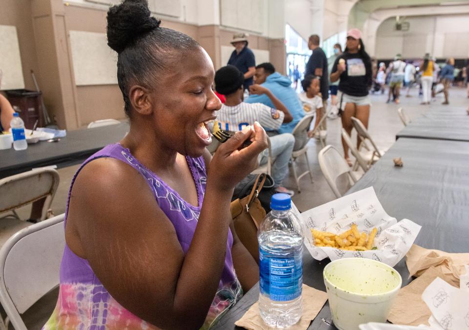 Quiana Jackson of Stockton eats garlic fries at the first California Garlic Festival at the San Joaquin County Fairgrounds on Saturday.