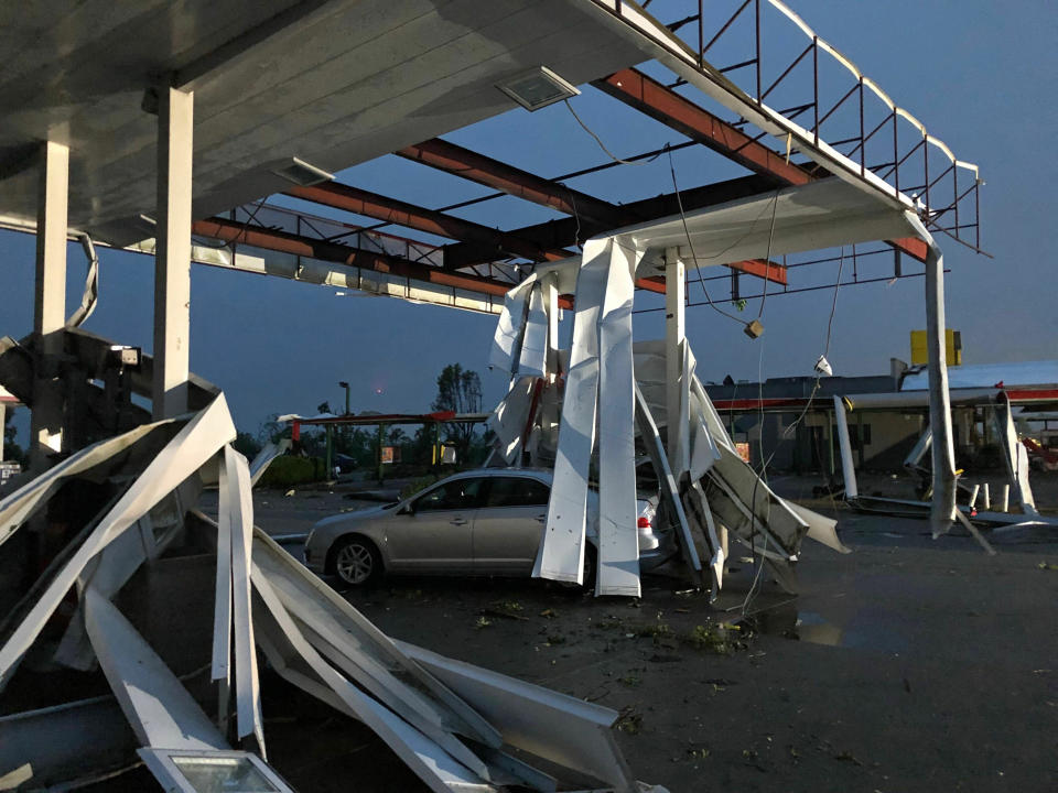 Un auto queda atrapado bajo los restos de un techo de una gasolinera en Jefferson City, Missouri, tras el paso de un tornado, el jueves 23 de mayo de 2019. (Foto AP/David A. Lieb)