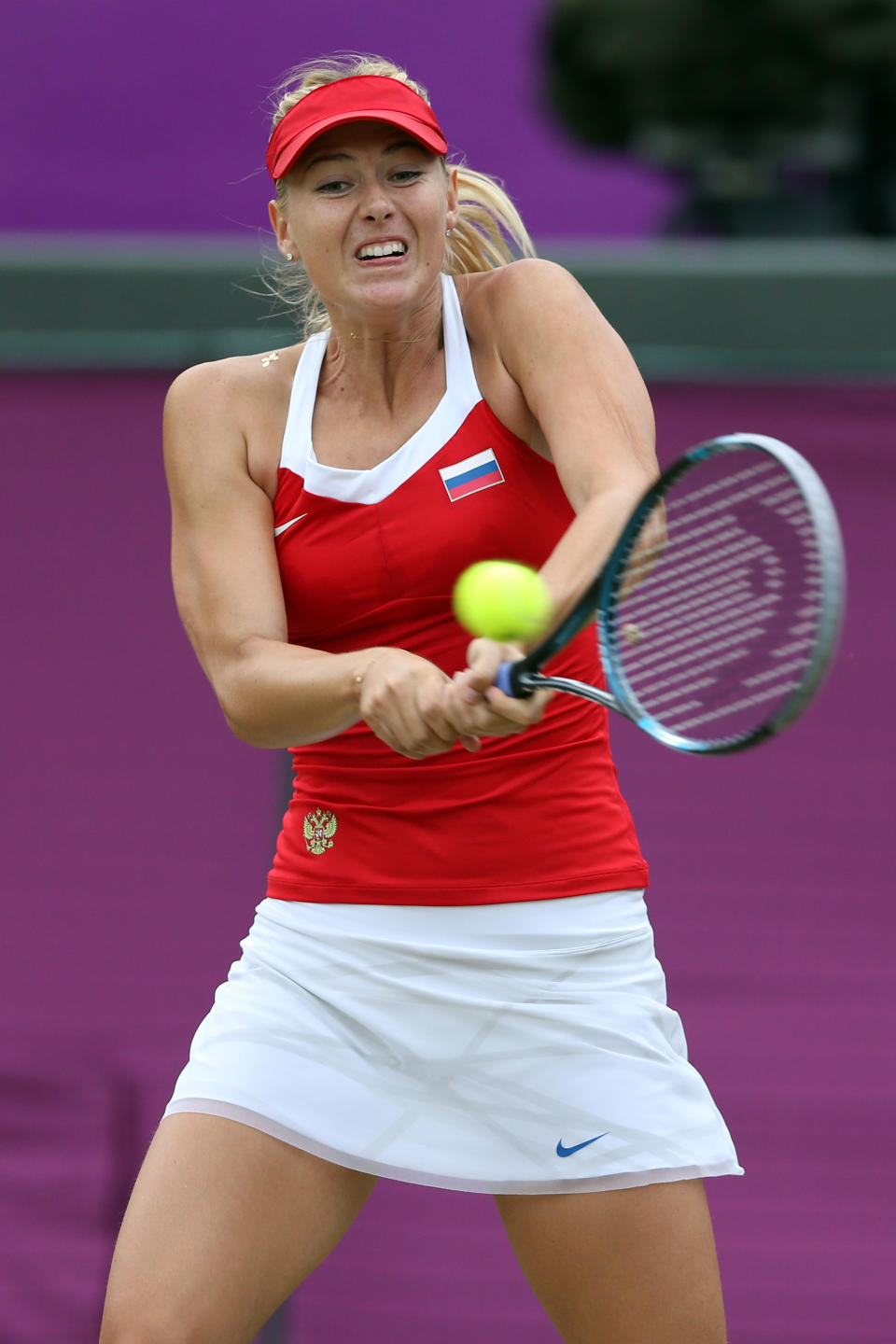LONDON, ENGLAND - AUGUST 01: Maria Sharapova of Russia returns the ball against Sabine Lisicki of Germany during the third round of Women's Singles Tennis on Day 5 of the London 2012 Olympic Games at Wimbledon on August 1, 2012 in London, England. (Photo by Clive Brunskill/Getty Images)
