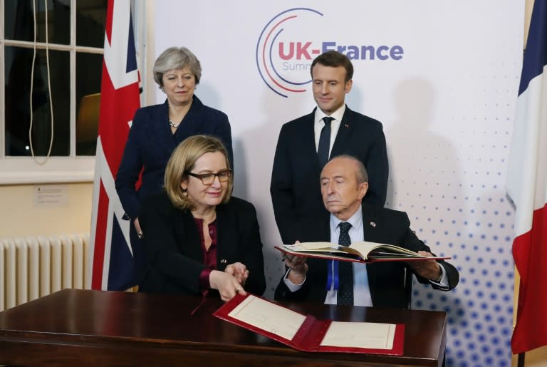 The British and French interior ministers, Amber Rudd amd Gerard Collomb, sign the new border security accord as Theresa May and Emmanuel Macron look on approvingly