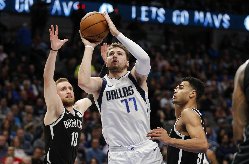 Dallas Mavericks forward Luka Doncic (77) attempts a shot as Brooklyn Nets guards Dzanan Musa (13) and Timothe Luwawu-Cabarrot (9) defend during the first half of an NBA basketball game Thursday, Jan. 2, 2020, in Dallas. (AP Photo/Brandon Wade)