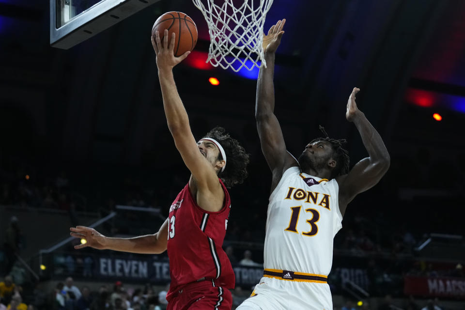 Iona's Nelly Junior Joseph (13) runs from behind to block Marist's Patrick Gardner shot during the first half of an NCAA college basketball game in the championship of the Metro Atlantic Athletic Conference Tournament, Saturday, March 11, 2023, in Atlantic City N.J. (AP Photo/Matt Rourke)