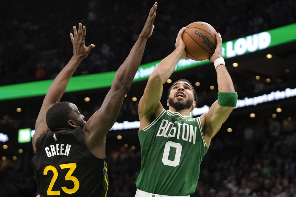 Boston Celtics forward Jayson Tatum (0) shoots at the basket as Golden State Warriors forward Draymond Green (23) defends in the second half of an NBA basketball game, Thursday, Jan. 19, 2023, in Boston. (AP Photo/Steven Senne)