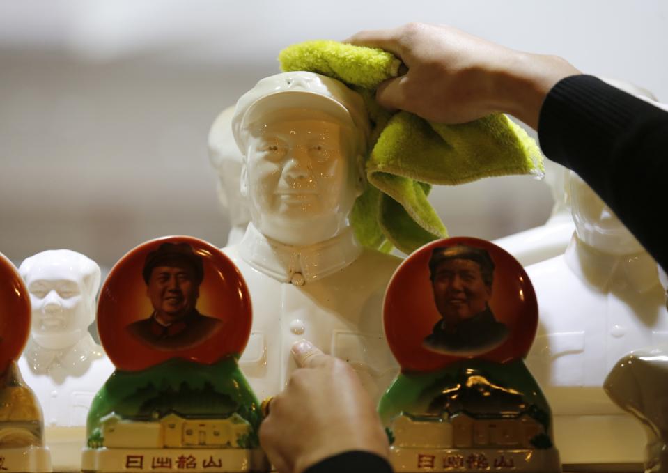 Clerk dusts off a bust of China's late Chairman Mao Zedong at an antique shop in Beijing