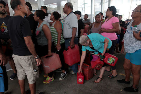 FILE PHOTO: People line up to buy gasoline at a gas station after the area was hit by Hurricane Maria, in San Juan, Puerto Rico September 22, 2017. Picture taken September 22, 2017. REUTERS/Alvin Baez/File Photo