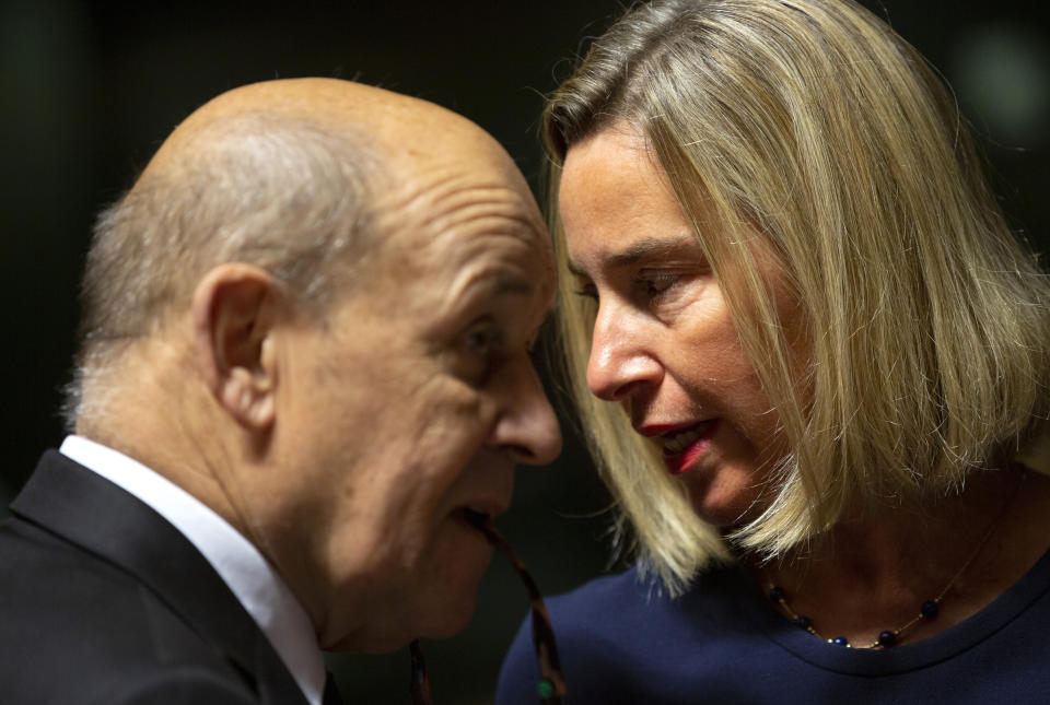 European Union foreign policy chief Federica Mogherini, right, speaks with French Foreign Minister Jean-Yves Le Drian during a meeting of EU foreign ministers at the European Convention Center in Luxembourg, Monday, Oct. 14, 2019. Some European Union nations are looking to extend moves against Turkey by getting more nations to ban arms exports to Ankara to protest the offensive in neighboring Syria. (AP Photo/Virginia Mayo)