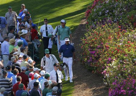 U.S. golfer Bubba Watson (C) and Australia's John Senden walk down the sixth hole during the third round of the Masters golf tournament at the Augusta National Golf Club in Augusta, Georgia April 12, 2014. REUTERS/Brian Snyder
