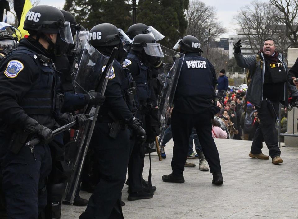 <div class="inline-image__caption"><p>Russell Taylor, right, is photographed flipping off cops at the U.S. Capitol on Jan. 6.</p></div> <div class="inline-image__credit">Andrew Caballero-Reynolds/Getty</div>