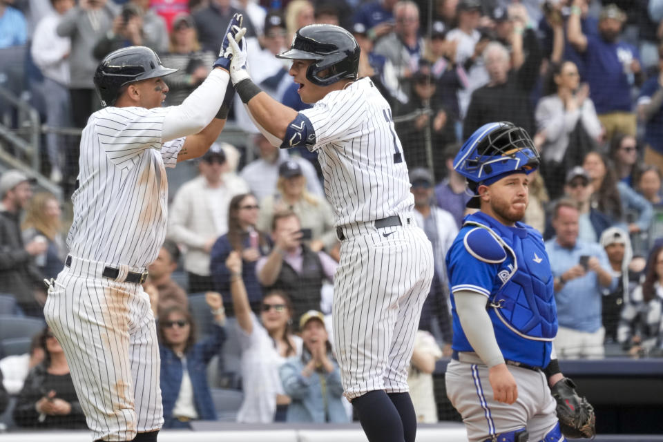 Toronto Blue Jays catcher Alejandro Kirk, right, reacts as New York Yankees' Anthony Volpe, center, and Oswald Peraza celebrate after scoring off of Volpe's two-run home run in the eighth inning of a baseball game against the Toronto Blue Jays, Saturday, April 22, 2023, in New York. (AP Photo/Mary Altaffer)