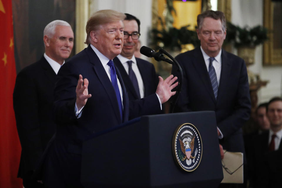 President Donald Trump, gestures, as Vice President Mike Pence, back left, Secretary of Treasury, Steven Mnuchin, back center, and U.S. Trade Representative Robert Lighthizer, right, listen during a signing ceremony of the "phase one" of a US China trade agreement, in the East Room of the White House, Wednesday, Jan. 15, 2020, in Washington. (AP Photo/Steve Helber)