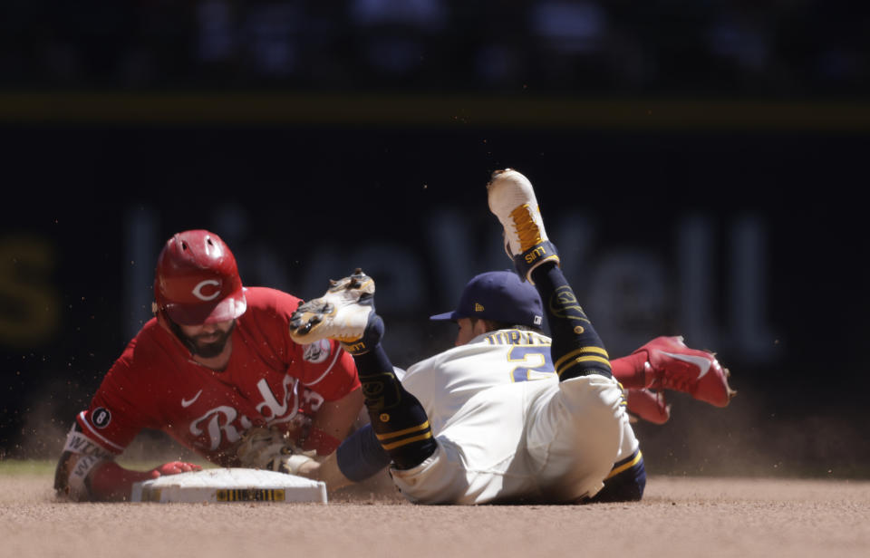 Cincinnati Reds right fielder Jesse Winker (33) is tagged out at second base by Milwaukee Brewers third baseman Luis Urias (2) during the sixth inning of a baseball game Wednesday, June 16, 2021, in Milwaukee. (AP Photo/Jeffrey Phelps)