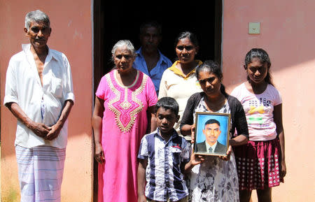 The family of H.G Kumarsinghe hold a portrait of the man, whose death at the hands of three Muslim men, sparked the rioting in Kandy, Sri Lanka March 18, 2018. REUTERS/Tom Allard