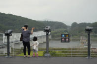 A visitor waves her hand toward the North's side at the Imjingak Pavilion in Paju, South Korea, near the border with North Korea, Monday, Oct. 4, 2021. North Korea restored dormant communication hotlines with South Korea in a small, fragile reconciliation step Monday in an apparent hard push to win outside concessions with a mix of conciliatory gestures and missile tests. (AP Photo/Ahn Young-joon)