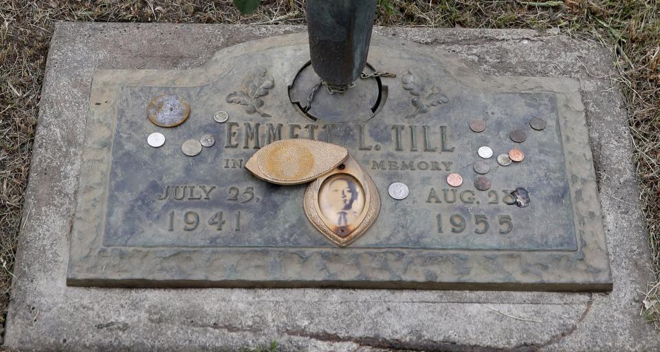 The grave marker of Emmett Till has a photo of Till and coins placed on it during a gravesite ceremony at the Burr Oak Cemetery marking the 60th anniversary of the murder of Till in Mississippi, Friday, Aug. 28, 2015, in Alsip, Ill. (AP Photo/Charles Rex Arbogast)