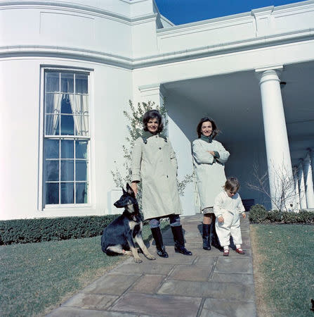 FILE PHOTO -- First Lady Jacqueline Kennedy (L) stands with her sister, Princess Lee Radziwill of Poland, and niece, Anna Christina Radziwill, on the walkway outside the Oval Office with the Kennedy family dog Clipper at the White House in Washington, D.C., January 15, 1963. Courtesy Cecil Stoughton/JFK Library/Handout via REUTERS