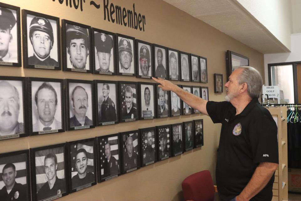 Joe Clure, the executive director of the Arizona Police Association, looks at photos of officers killed in the line of duty. The organization describes itself as “an association of associations.” (Photo by Sarah Emily Baum/News21)