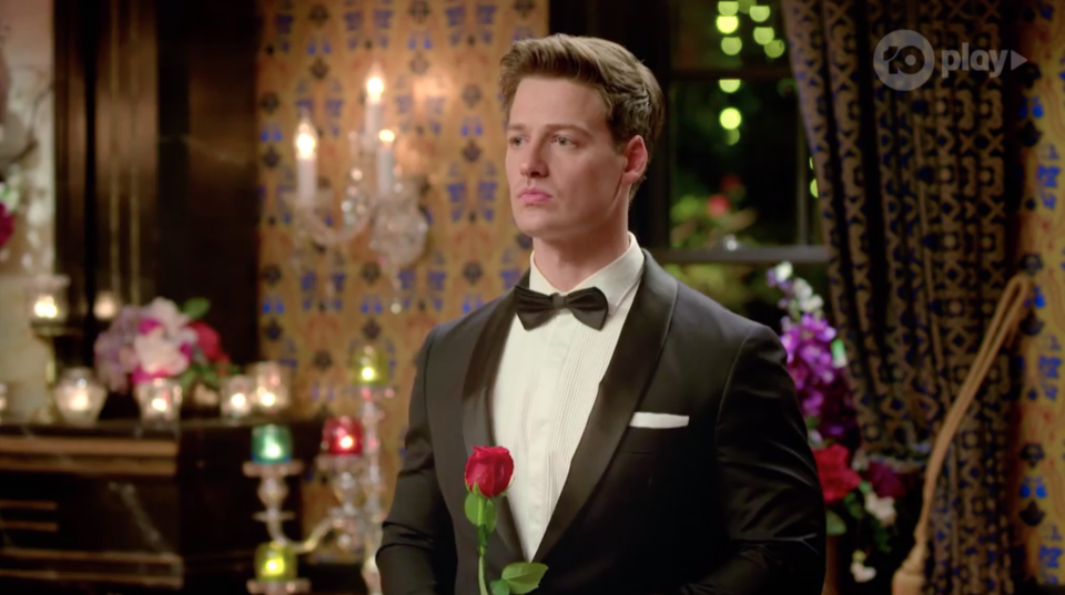 Bachelor Matt Agnew holds a rose at the rose ceremony