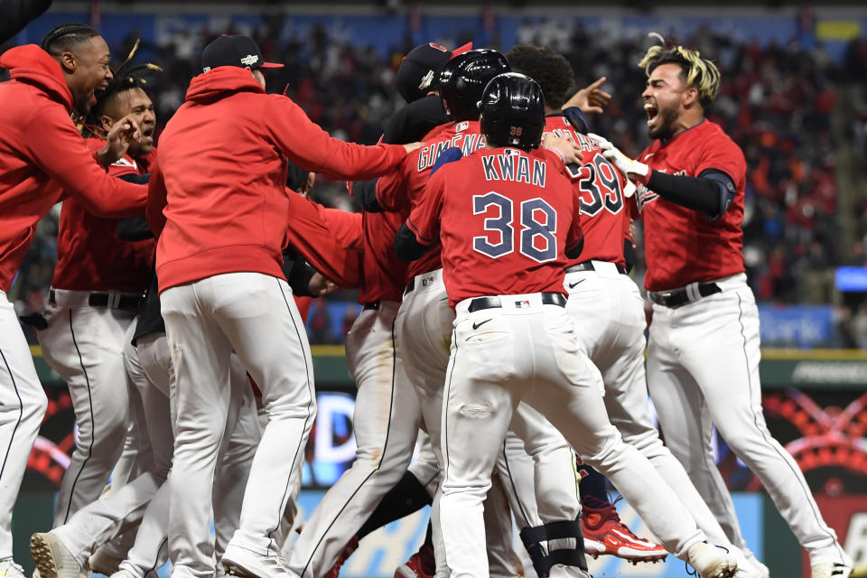 Cleveland Guardians' Oscar Gonzalez (39) is mobbed by teammates after driving in the winning run against the New York Yankees during the ninth inning of Game 3 of a baseball AL Division Series, Saturday, Oct. 15, 2022, in Cleveland. The Guardians won 6-5. (AP Photo/David Dermer)
