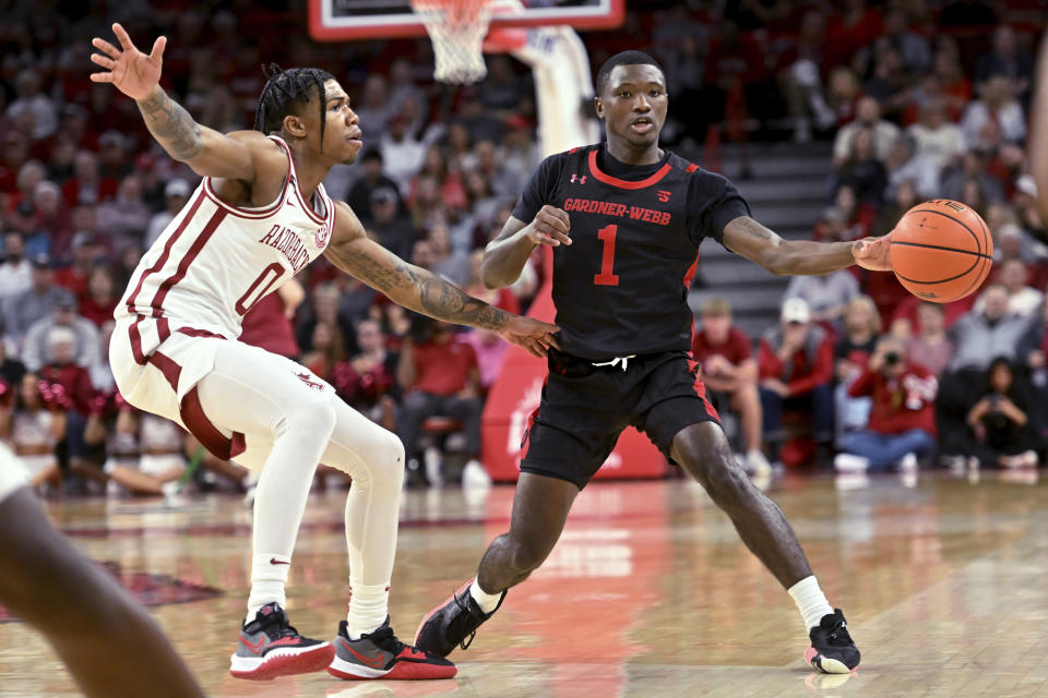 Gardner-Webb guard Julien Soumaoro (1) passes the ball away from Arkansas guard Khalif Battle (0) during the first half of an NCAA college basketball game Friday, Nov. 10, 2023, in Fayetteville, Ark. (AP Photo/Michael Woods)