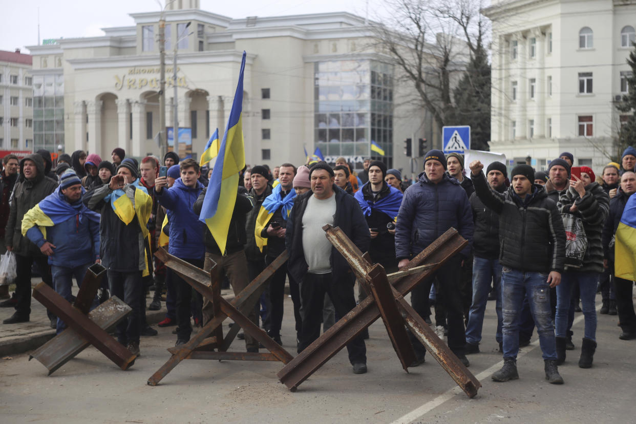 FILE - People shout toward Russian army soldiers during a rally against the Russian occupation in Svobody (Freedom) Square in Kherson, Ukraine, on March 7, 2022. According to Russian state TV, the future of the Ukrainian regions occupied by Moscow's forces is all but decided: Referendums on becoming part of Russia will soon take place there, and the joyful residents who were abandoned by Kyiv will be able to prosper in peace. In reality, the Kremlin appears to be in no rush to seal the deal on Ukraine's southern regions of Kherson and Zaporizhzhia and the eastern provinces of Donetsk and Luhansk. (AP Photo/Olexandr Chornyi)