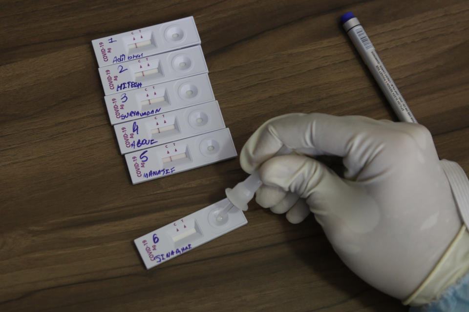 An Indian health worker collects a nasal swab sample of roadside vendor at a health centre in Ahmedabad, India, Wednesday, July 8, 2020. India has overtaken Russia to become the third worst-affected nation by the coronavirus pandemic. (AP Photo/Ajit Solanki)