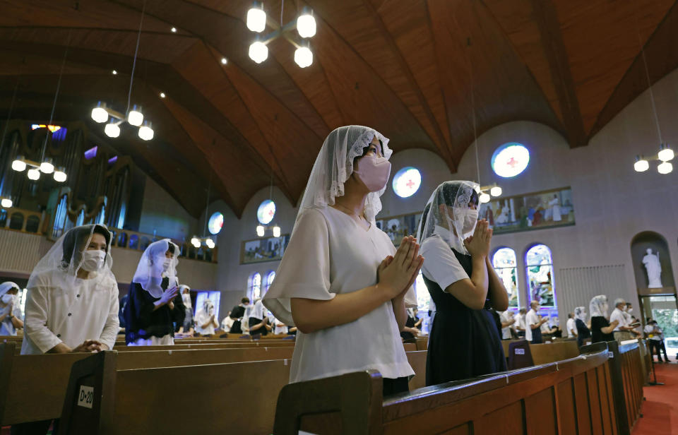 Catholics attend an early morning Mass at the Urakami Cathedral on the 77th anniversary of the atomic bombing in Nagasaki, southern Japan, Tuesday, Aug. 9, 2022. (Kyodo News via AP)