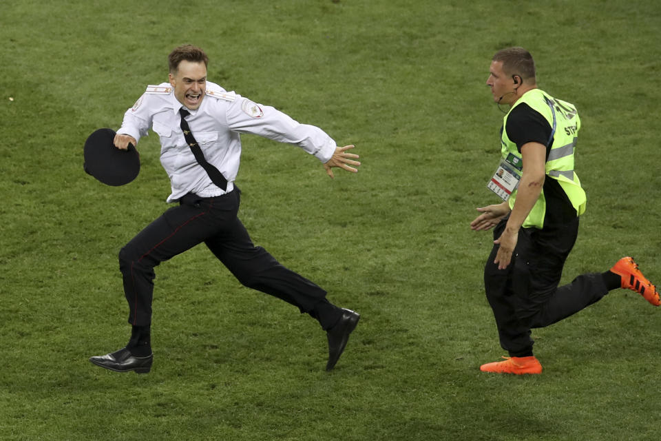 ARCHIVO - Pyotr Verzilov es perseguido por un guardia tras invadir la cancha durante la final de la Copa Mundial de Fútbol 2018 entre Francia y Croacia en el Estadio Luzhniki en Moscú, Rusia en una fotografía de archivo del 15 de julio de 2018. Los médicos alemanes que tratan a Pyotr Verzilov, miembro del grupo activista ruso Pussy Riot, dijeron el martes 18 de septiembre que las afirmaciones de que fue envenenado son “altamente plausibles” basándose en sus síntomas. (Foto AP/Thanassis Stavrakis, archivo)