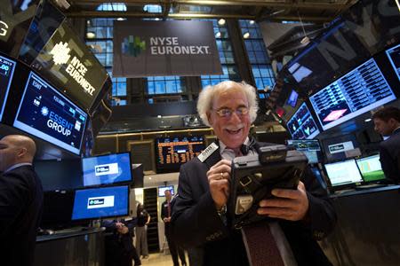 Trader Peter Tuchman smiles as he works on the floor of the New York Stock Exchange after the market opening in New York, December 23, 2013. REUTERS/Carlo Allegri