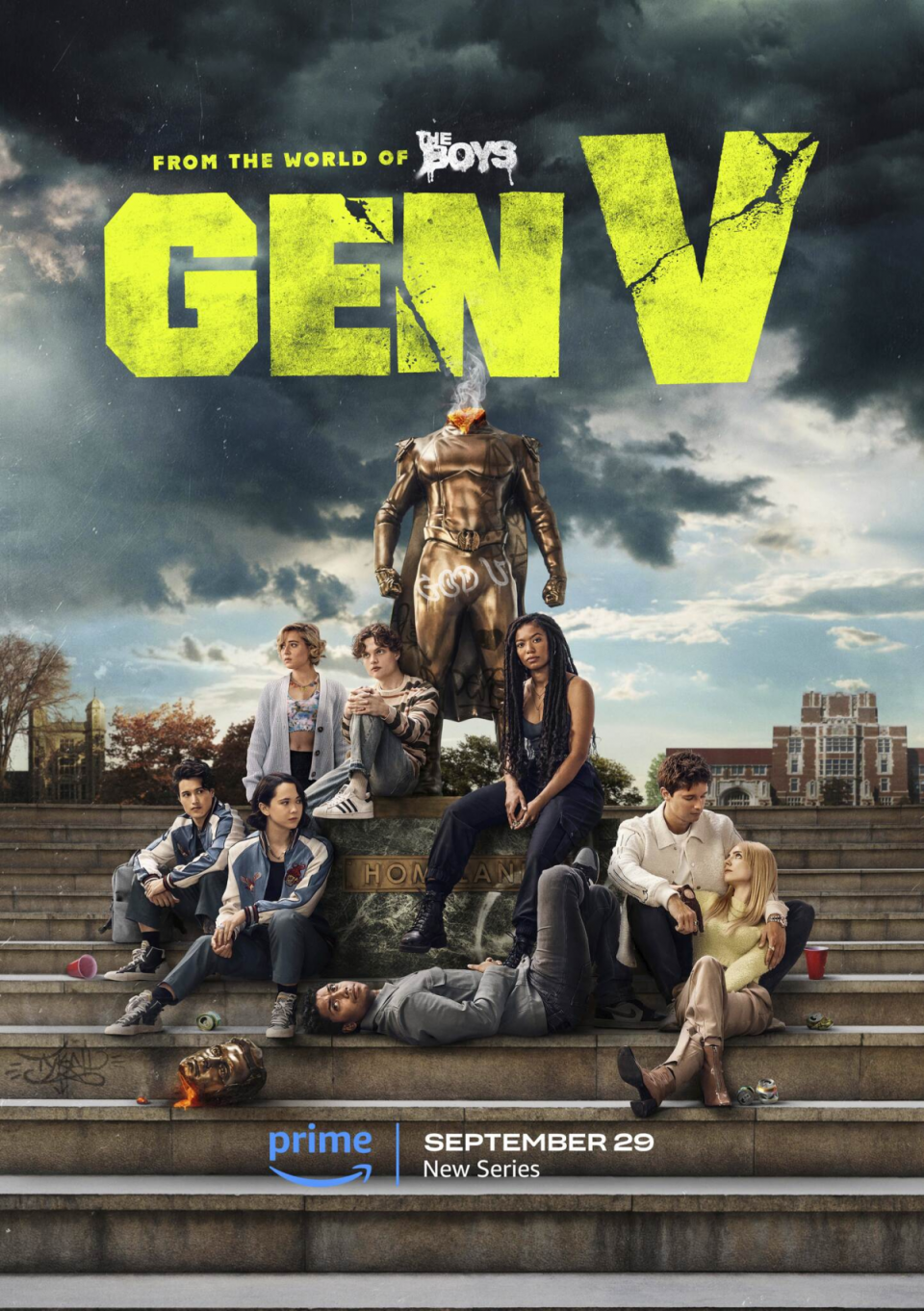 the cast of gen v sit on steps together at a college in front of a superhero statue with the head missing