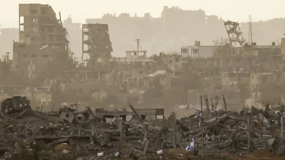 An Israeli flag flies among debris in Gaza, amid the ongoing conflict between Israel and Hamas, as seen from southern Israel, on December 12, 2023. - Clodagh Kilcoyne/Reuters