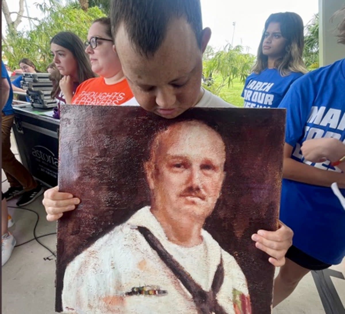 Corey Hixon holds a drawing of his father Chris at the March for Our Lives rally in June 2022 (Debbi Hixon/Twitter)