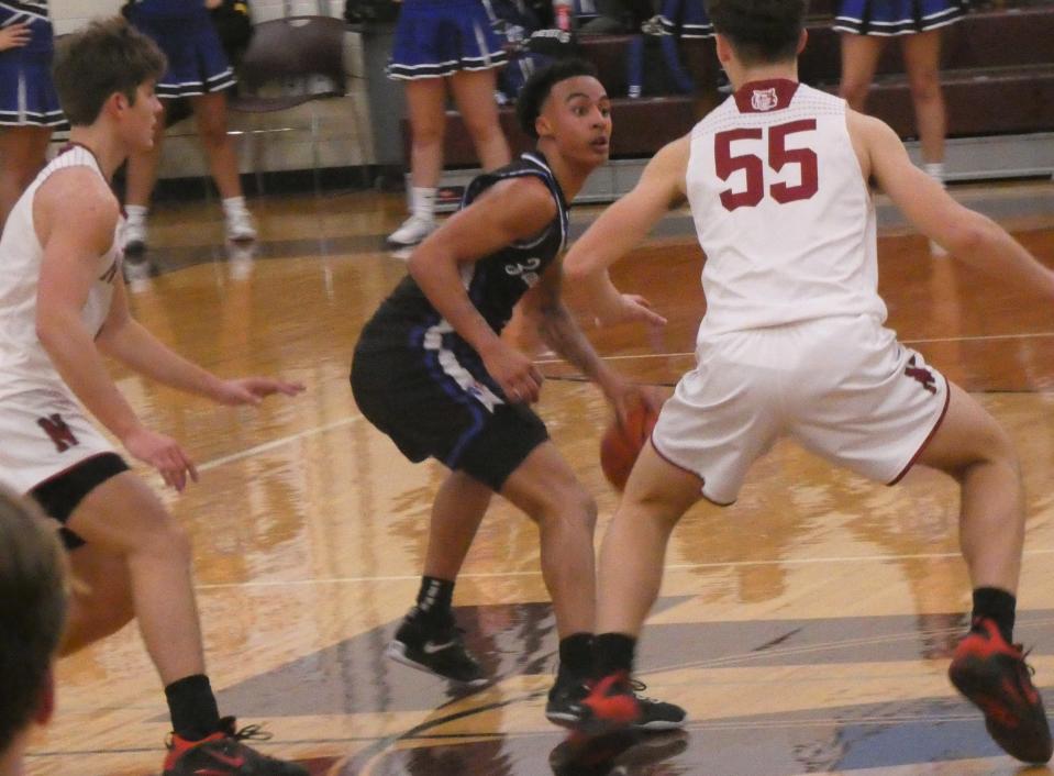 Zanesville junior Rashaud Hampton looks for help against defense from Newark junior Ethan Stare and sophomore Austin Rose (55) at Jimmy Allen Gymnasium on Saturday, Dec. 3, 2022. The host Wildcats beat the Blue Devils 64-29, their 11th consecutive victory in the rivalry.