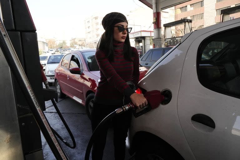 Una mujer llena el depósito de su coche en una gasolinera en Teherán, Irán, el lunes 18 de diciembre de 2023. Casi el 70% de las gasolineras de Irán quedaron fuera de servicio el lunes tras un posible sabotaje, en referencia a los ciberataques, informó la televisión estatal iraní. (AP Photo/Vahid Salemi)