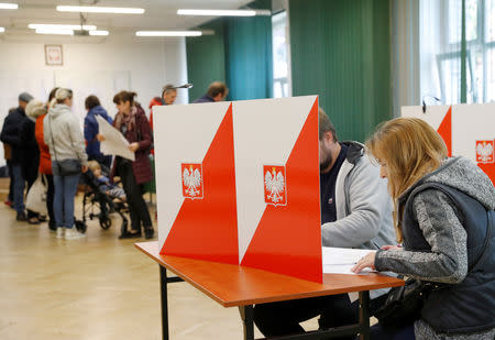 People attend the Polish regional elections, at a polling station in Warsaw, Poland, October 21, 2018. REUTERS/Kacper Pempel