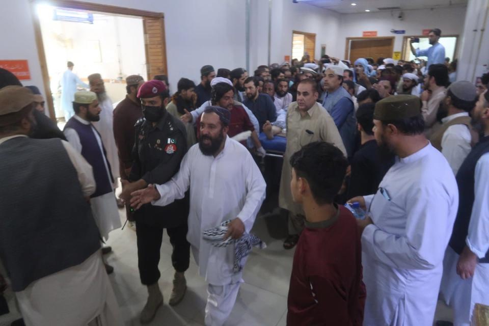 Police escort victims of the blast as they are moved at a hospital in Quetta (EPA)