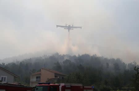 A firefighting plane drops water to extinguish a fire in village of Strinjine near Split, Croatia, July 18, 2017. REUTERS/Antonio Bronic