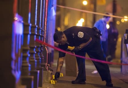 FILE PHOTO - A Chicago police officer collects evidence at a crime scene where a man was shot in Chicago, Illinois, United States, July 5, 2015. REUTERS/Jim Young