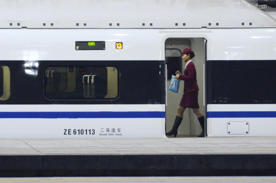 A stewardess walks inside a high-speed train running from the Beijing to Guangzhou, south China's Guangdong province, at the Beijing west railway station in Beijing on December 26, 2012. China on December 26 started service on the world's longest high-speed rail route, the latest milestone in the country's rapid and sometimes troubled super fast rail network. AFP PHOTO / WANG ZHAO
