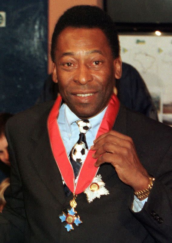 PELE SHOWS OFF HIS KBE MEDAL AT CHELSEA'S FOOTBALL GROUND IN LONDON