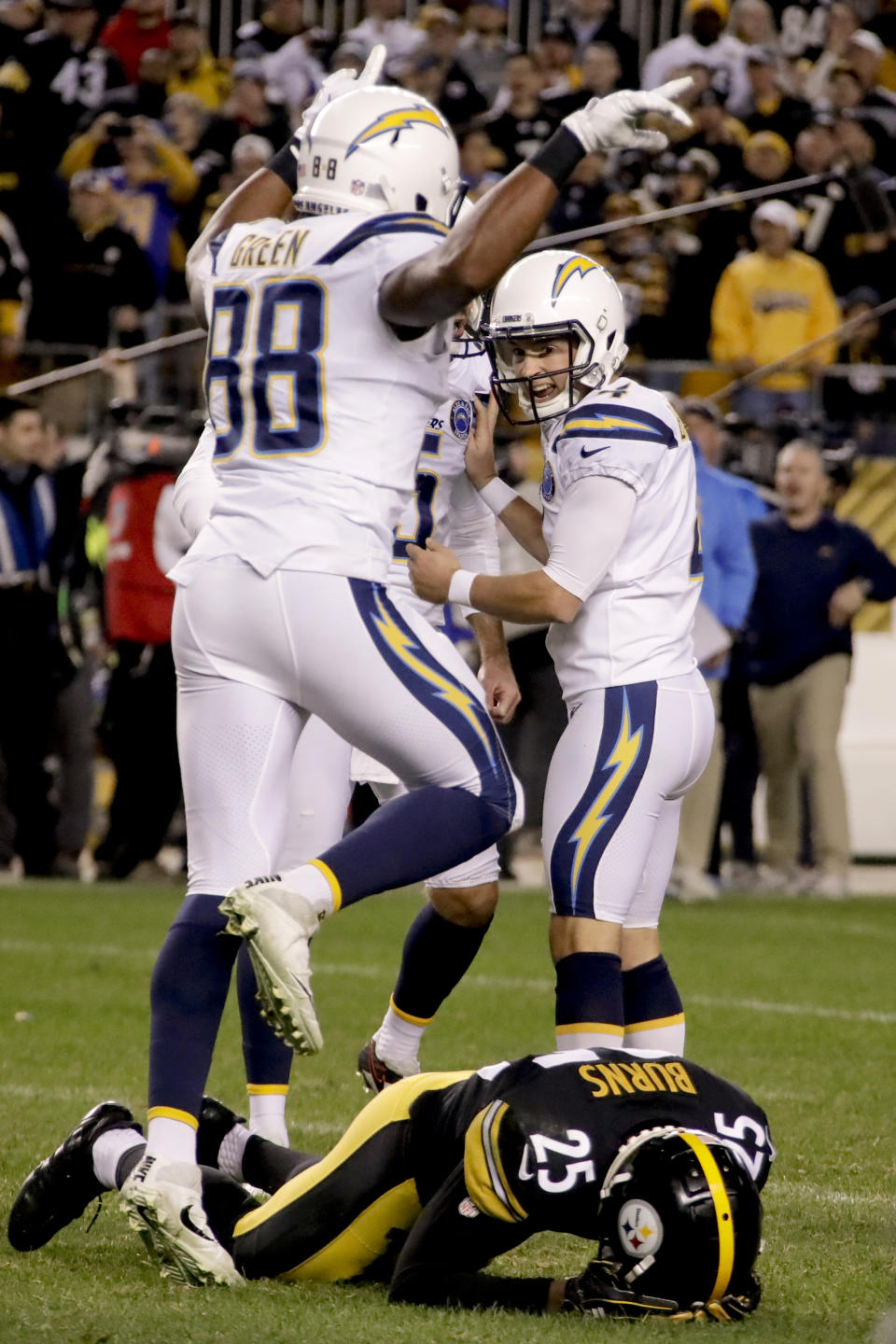 Los Angeles Chargers tight end Virgil Green (88) jumps over Pittsburgh Steelers cornerback Artie Burns (25) on his way to congratulate kicker Mike Badgley (4) after Badgley hit a field goal with no time left on the clock in the second half of an NFL football game to defeat the Pittsburgh Steelers 33-30, Sunday, Dec. 2, 2018, in Pittsburgh. (AP Photo/Gene J. Puskar)